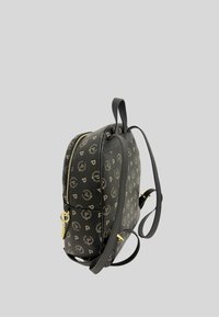 Zaino nero con accenti dorati e motivo a logo. Presenta una chiusura con zip, due spallacci e una maniglia superiore. Materiale sintetico testurizzato.