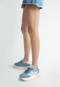 Sneaker blu con tomaia in tessuto testurizzato, design a stella bianca come accentuazione e suola chiara. Piattaforma elevata per un'altezza extra.