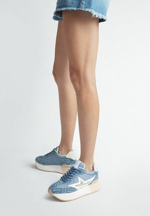 Sneaker blu con tomaia in tessuto testurizzato, design a stella bianca come accentuazione e suola chiara. Piattaforma elevata per un'altezza extra.
