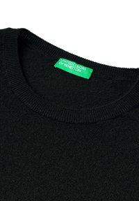Černý pletený svetr s kulatým výstřihem a zelenou etiketou přišitou uvnitř límce, na které je napsáno "UNITED COLORS OF BENETTON."