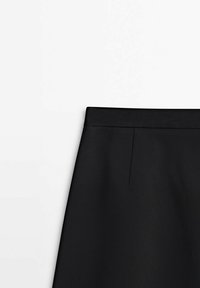 Jupe noire droite avec une taille haute, des coutures visibles et un détail subtil de couture avant sur fond blanc.