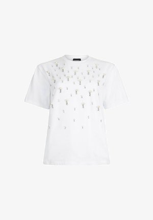 Camiseta blanca de manga corta con adornos de perlas y strass dispersos en la parte frontal, que presenta un escote redondo y un corte relajado.