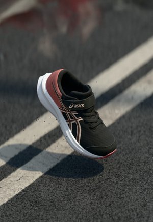 Čierna a červená bežecká obuv vyrobená z ľahkého materiálu, s pohodlnou bielou podrážkou a suchým zipsom pre podporu.