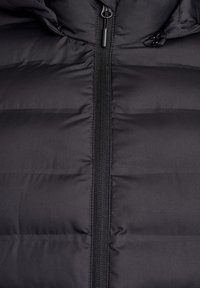 Must kõrgkaelusega jope horisontaalsete tikanditega, esiosal lukuga ja kapuutsiga. Materjal paistab sile ja veidi läikiv.