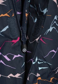 Giacca a vento realizzata in tessuto blu navy con motivo a spina di pesce, forme astratte colorate in rosa, viola, arancione e turchese, e chiusura con zip.