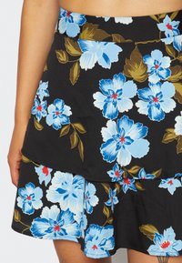 Black floral skirt featuring blue and white flowers with red accents, layered design, and a smooth fabric texture.