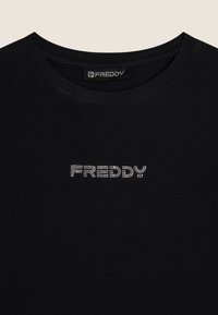 Musta puuvillapaita, jossa on pyöreä kaula-aukko ja rhinestone-koristeinen "FREDDY"-logo rinnassa. Pehmeä tekstuuri ja vartalonmyötäinen muotoilu.