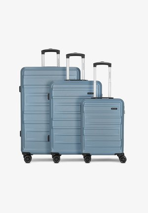 Drie geneste koffers van lichtblauw plastic, met gestructureerde oppervlakken, zwarte accenten, uitschuifbare aluminium handvatten en elk vier zwarte wielen.