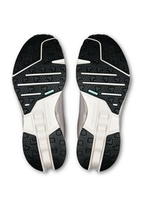 Die Schuhsohle verfügt über eine strukturierte schwarze Gummifläche mit einem geometrischen Muster, weißen seitlichen Akzenten und einem kleinen blauen Detail in der Nähe der Zwischensohle.
