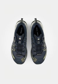 Navy blue athletic shoes with mesh upper, reinforced toe, lacing system, and gray accents. Features a pull tab on the heel for easy wear.