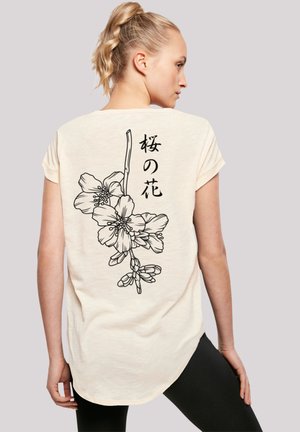 Cream short-sleeve top featuring a line-drawn cherry blossom design and Japanese text on the back; smooth texture and relaxed fit.