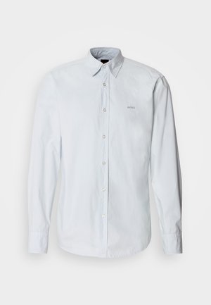 Svijetloplava košulja dugih rukava s gumbima i klasičnim ovratnikom. Na prsima se nalazi diskretan logo, a sprijeda su vidljivi gumbi.