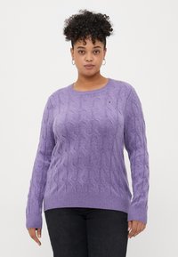 Lavendelfarbener Kabelstrickpullover mit Rundhalsausschnitt und gerippten Bündchen, der ein kleines Logo-Detail auf der Brust und eine lässige Passform aufweist.