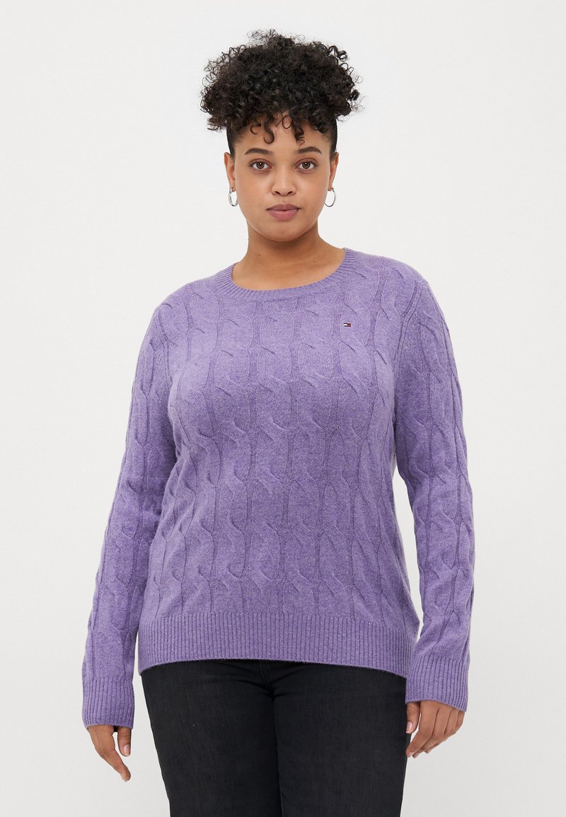 Lavendelfarbener Kabelstrickpullover mit Rundhalsausschnitt und gerippten Bündchen, der ein kleines Logo-Detail auf der Brust und eine lässige Passform aufweist.