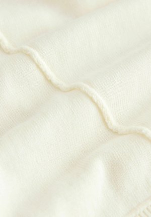 Kreemvärvi kangas, millel on tekstureeritud laineline muster ja esile tõstetud õmblused. Pehme, sile tekstuur ja peened koed.