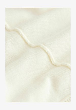 Krém színű szövet, mely texturált, hullámos mintával és kiemelkedő varrási részletekkel rendelkezik. Puha, sima tapintású, finom szövésű anyag.