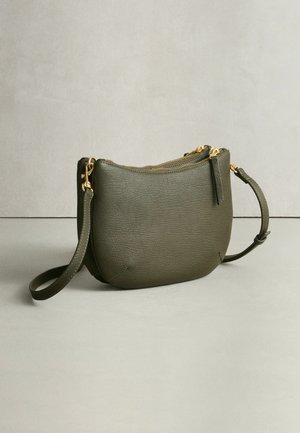 Kožená kabelka cez rameno v olivovo zelenej farbe s guľatým tvarom, textúrovaným povrchom, zlatými zipsami a odnímateľným remienkom.