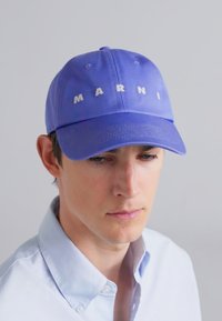 Violetā beisbola cepure ar izšūtu "MARNI" tekstu, izgatavota no gludas materiāla; ar noapaļotu malu un ventilācijas atverēm.