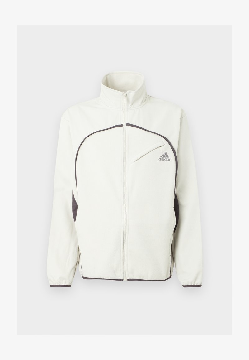 Witte ritsjack met zwarte accenten, voorzien van een staande kraag, elastische manchetten en een logo op de linkerkant van de borst in het grijs. Textuur van de stof.