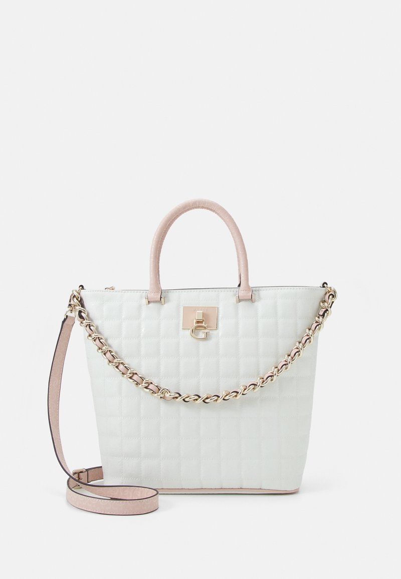Sac à main matelassé blanc avec anses rose clair, bandoulière chaîne dorée et fermoir logo doré sur fond uni.