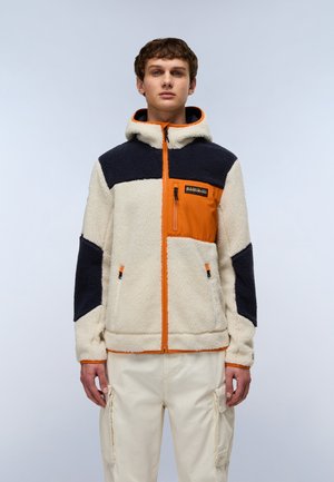 Fleecejacke mit einem cremefarbenen Körper und marineblauen Ärmeln, ausgestattet mit einem orangenen Reißverschluss, einer Brusttasche und einem schwarzen Markenlabel. Kapuzen-Design.