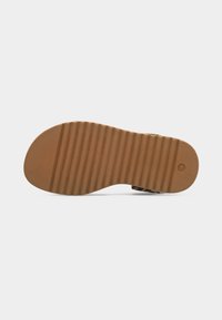 Σόλα καφέ σανδάλι με οριζόντιες αυλακώσεις, μέγεθος 26 σημειωμένο στη φτέρνα, απομονωμένη σε λευκό φόντο.