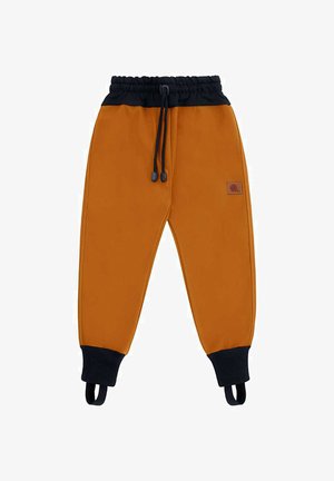 Spodnie dresowe w kolorze rdzy z czarnym elastycznym pasem, czarnymi mankietami z paskami na stopy oraz małą skórzaną naszywką na prawej udzie.