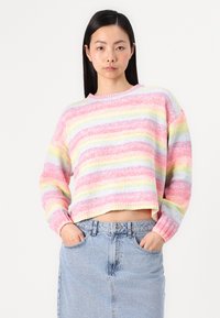 Multikleurige cropped sweater in pastelroze, geel en blauwe strepen; zachte textuur met geribbelde boorden en halslijn. Spijkerrok zichtbaar eronder.
