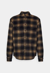 Camicia in flanella a quadri nera e marrone con bottoni sul davanti, due tasche sul petto e colletto. Tessuto morbido, materiale caldo, design casual.