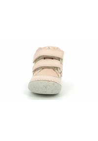 Zapato de cuero rosa con una parte superior texturizada, que presenta tres correas de velcro y una suela de goma blanca salpicada. Diseño de punta redonda.