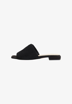 Sandale à glissière en suède noir avec un design supérieur large et angulaire, et une semelle plate avec un léger talon. Texture lisse avec un style minimaliste.