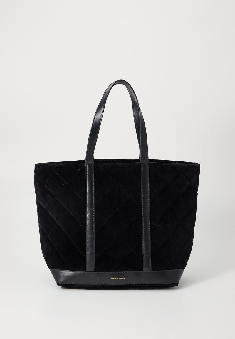 Sac cabas matelassé noir avec poignées et finitions en cuir, avec petit logo doré « Vanessa Bruno » en bas au centre.