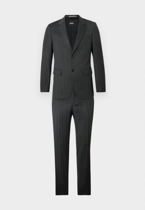 Donkergrijs pak met streeppatroon; enkelgelaagd jasje met twee knopen, gelapte revers en platte broekspijpen.