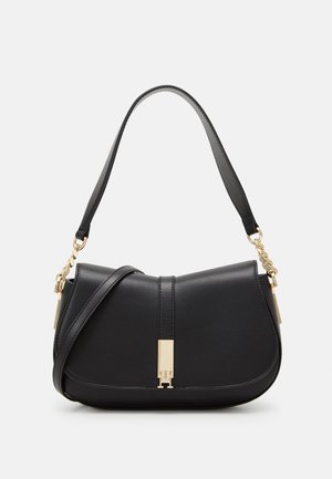 Sac à épaule en cuir noir avec rabat courbé, fermoir doré et détails en chaîne, avec deux options de bandoulière sur fond clair.