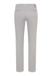 Leicht beige Schlank geschnittene Hose, von hinten gezeigt, mit Gürtelschlaufen, zwei paspelierten Taschen mit Knöpfen und einem kleinen Markenlabel auf dem Bund.