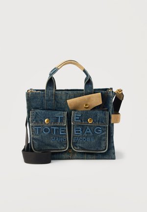 Denim Marc Jacobs totebag met twee voorzakken met knopen en accenten van lichtbruin leer, met de tekst "THE TOTE BAG" en een zwarte schouderriem.