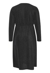 Robe noire à manches longues avec une taille froncée et un effet subtilement scintillant, vue de dos.