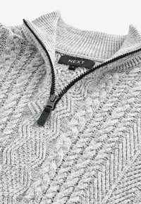 Szary wełniany sweter z zamkiem przy kołnierzu, z wykończeniem w stylu warkocza i prążkowanymi akcentami. Etykieta marki "NEXT" jest widoczna wewnątrz.