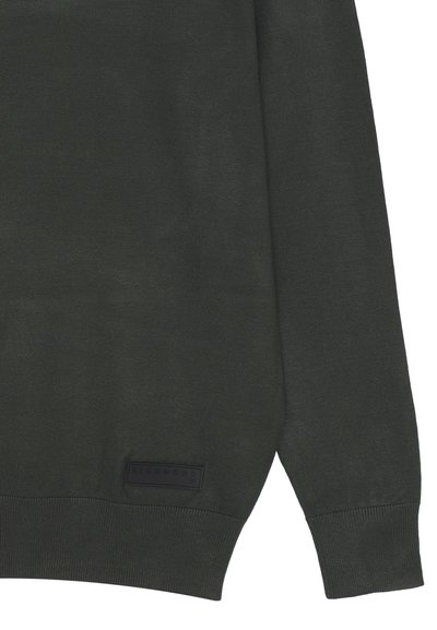 Maglione in maglia verde scuro con scollatura a girocollo. Presenta polsini e orlo a coste, e un'etichetta nera rettangolare in basso a sinistra con testo in rilievo.