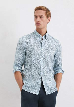 Light blue button-up shirt with floral pattern, long sleeves rolled to elbows, and a soft texture. Slim fit with a collar and button closure.