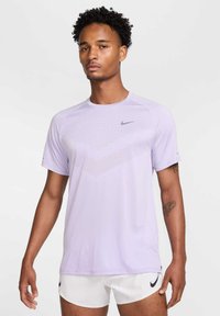 Light purple short-sleeve athletic shirt with a textured design on the front, featuring a small grey Nike logo on the upper left side.
