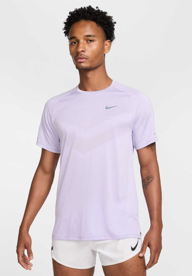 Light purple short-sleeve athletic shirt with a textured design on the front, featuring a small grey Nike logo on the upper left side.