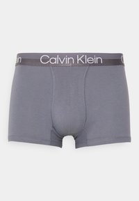 Grå boxershorts laget av mykt stoff, med en logo på elastisk midjebånd og tydelig søm for ekstra støtte og struktur.