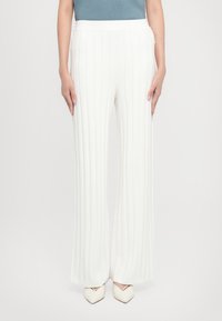 Pantalons plissés blancs avec une coupe large. Fabriqués en tissu doux, avec une texture lisse et une taille élastique.