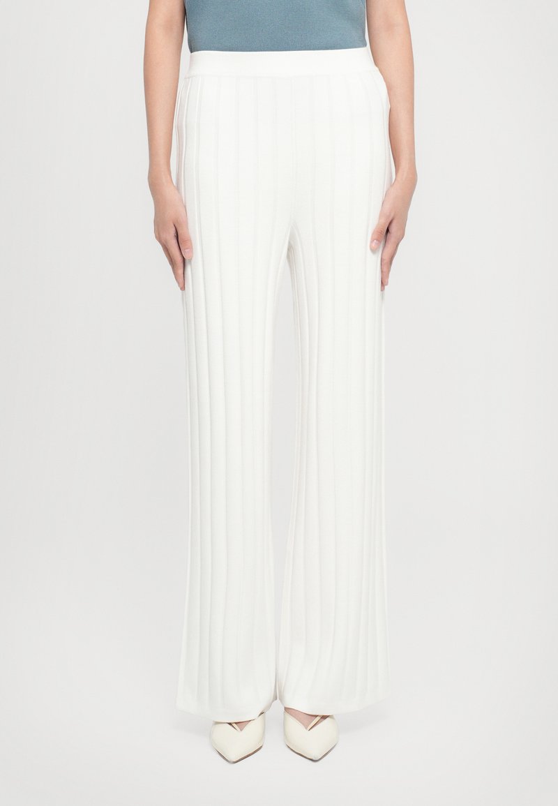 Pantalons plissés blancs avec une coupe large. Fabriqués en tissu doux, avec une texture lisse et une taille élastique.
