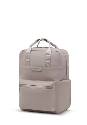 Sac à dos rectangulaire beige avec poignées supérieures, poche avant zippée, poche latérale et écusson logo Kapten & Son au centre avant.