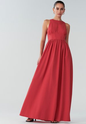 Dlouhé, bezrukávové červené šaty vyrobené z měkké látky. Přiléhavý korzet s nabíráním v pase, který vytváří splývavý A-čkový siluetu. Rovný lem.