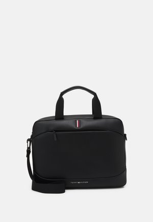 Czarna torba na laptopa Tommy Hilfiger z górnymi uchwytami, przednią kieszenią na zamek, odpinanym paskiem na ramię oraz logo na przednim panelu.