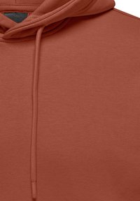 Ziegelrote Kapuzenjacke mit weicher Textur, ausgestattet mit einem Kordelzug und gerippten Bündchen, die ein einfaches, minimalistisches Design zeigt.