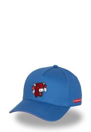 Casquette de baseball en coton bleu avec un visage de vache brodé en rouge et blanc. Comprend une petite étiquette rouge avec du texte sur le côté.